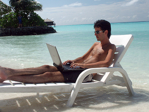 working on vacation laptop beach